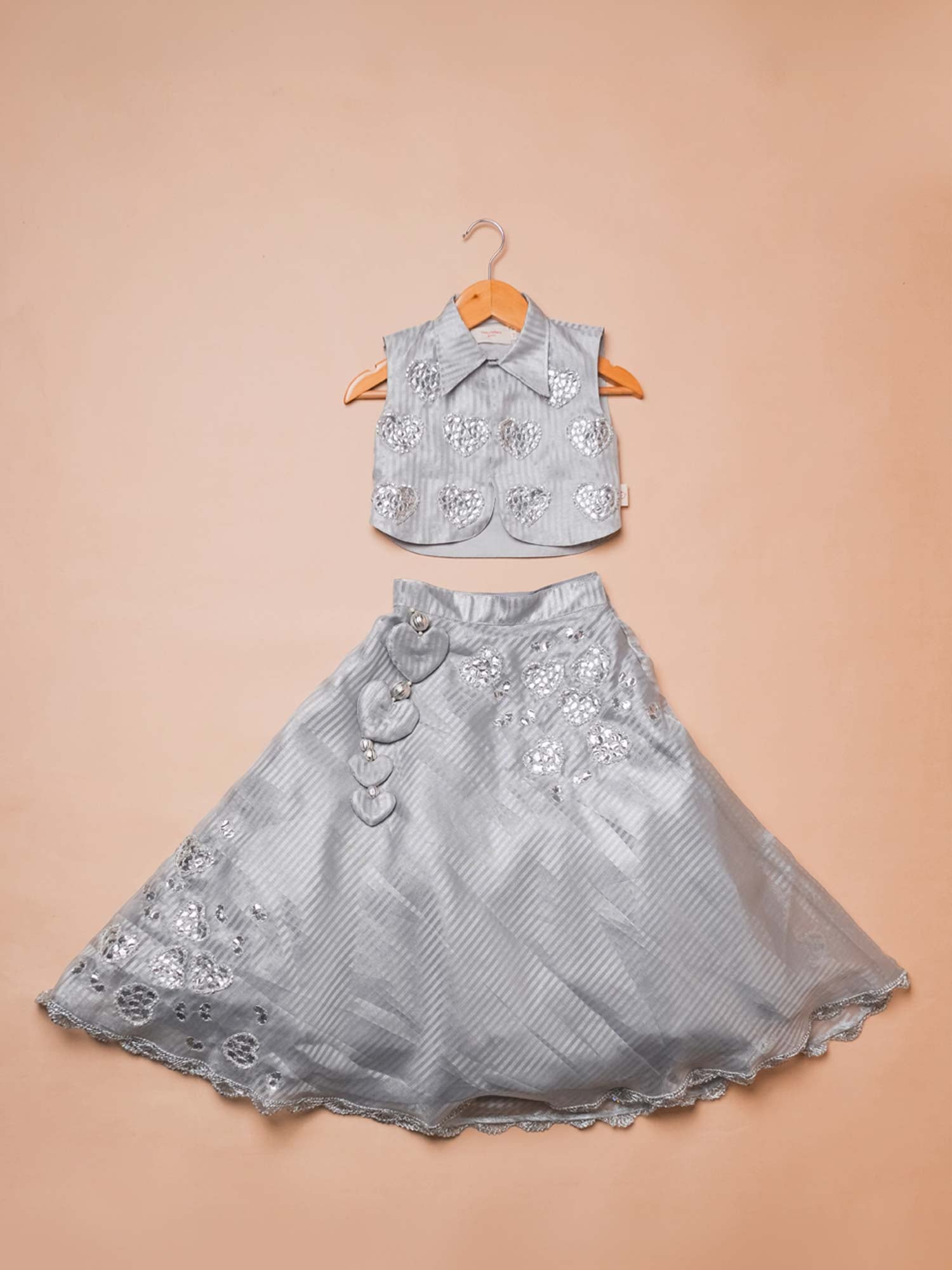 Girls festive silver organza lehenga choli set with hand-embroidered gota heart motifs and scalloped trims.