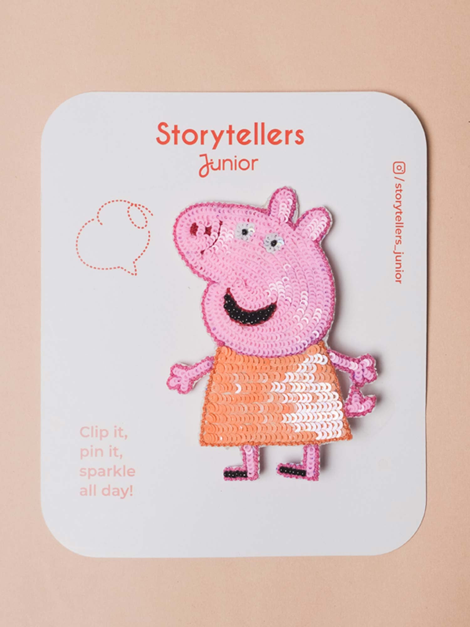 Pink hand-embroidered Peppa Pig brooch pin featuring shimmering pink and orange sequin details displayed on a StorytellersJunior branded backing card.