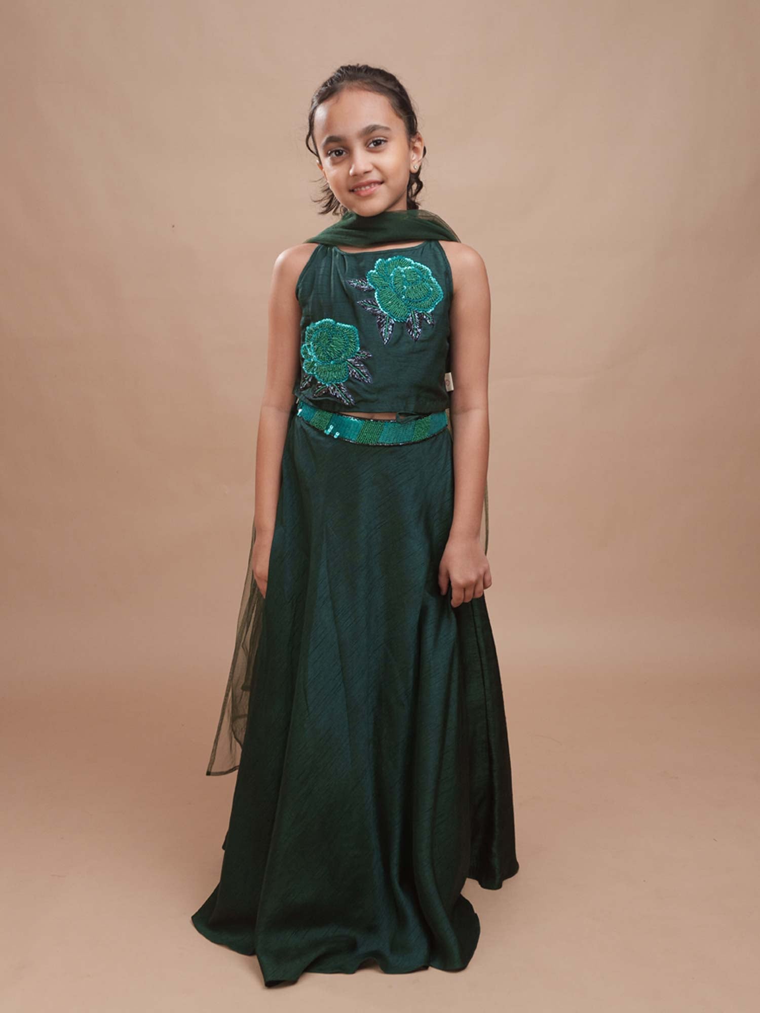 Young girl modeling the Emerald Green Roses Lehenga featuring a bamber silk blouse and a flared skirt with a tulle dupatta.