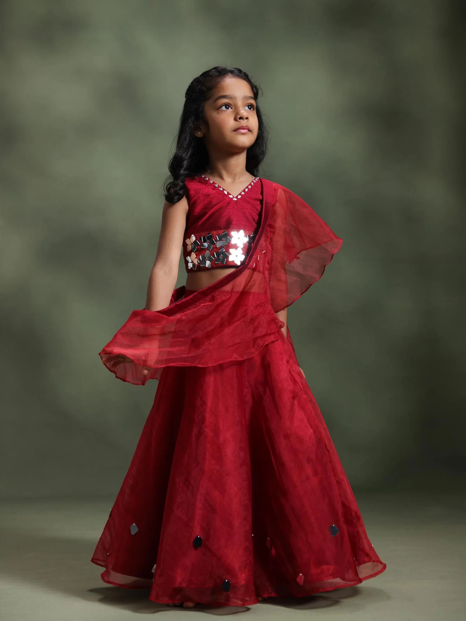 Girl wearing Storytellers Junior Ruby Mirror Lehenga Set in red with mirror embellishments and ruffle dupatta