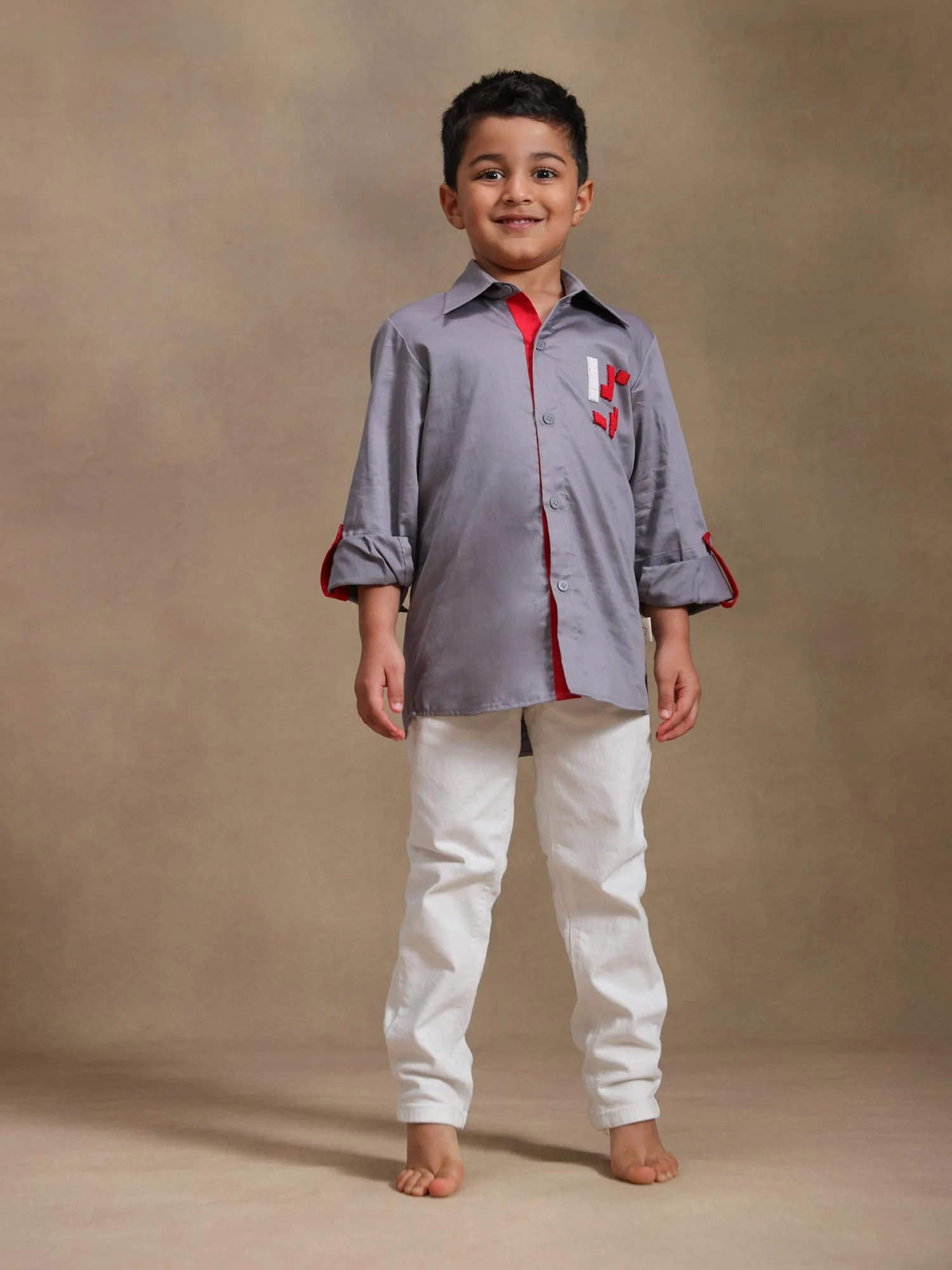 Boy wearing Storytellers Junior Tetris Tales Grey Shirt with geometric motifs and red accents
