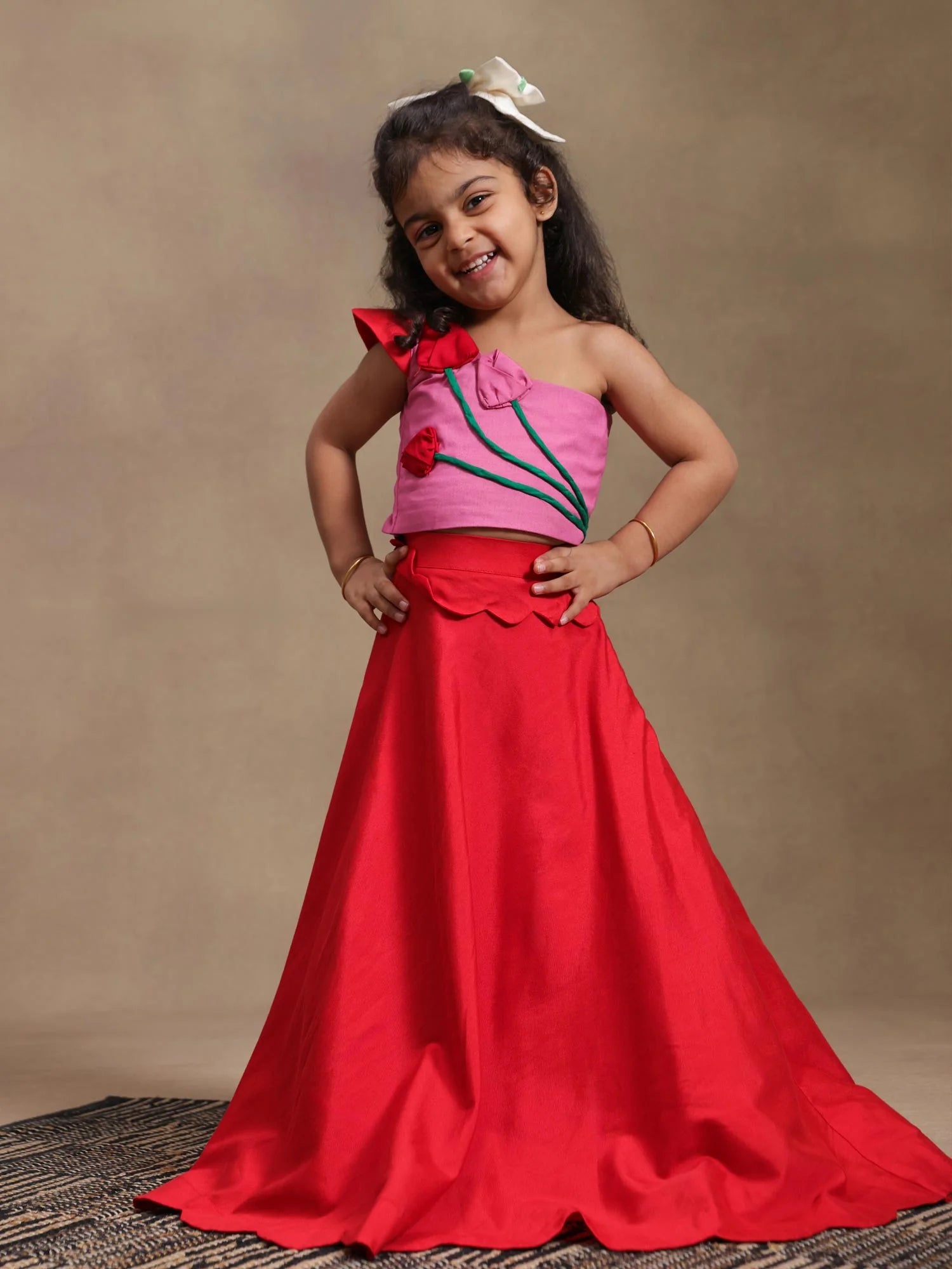 Girl wearing Storytellers Junior Tulip Bloom Lehenga Set in crimson with handmade tulip appliquŽs