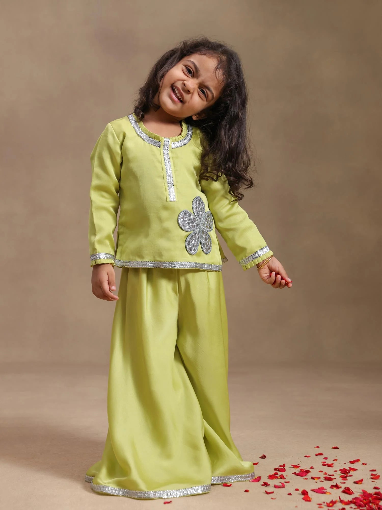 Girl wearing Storytellers Junior Kaya Lime Gota Sharara Set with handmade gota patti floral detailing