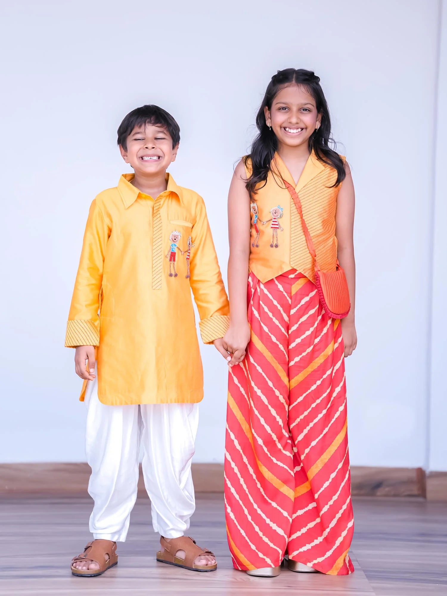 Boy wearing Storytellers Junior Kiran Orange Kurta Cowl Set with handcrafted detailing