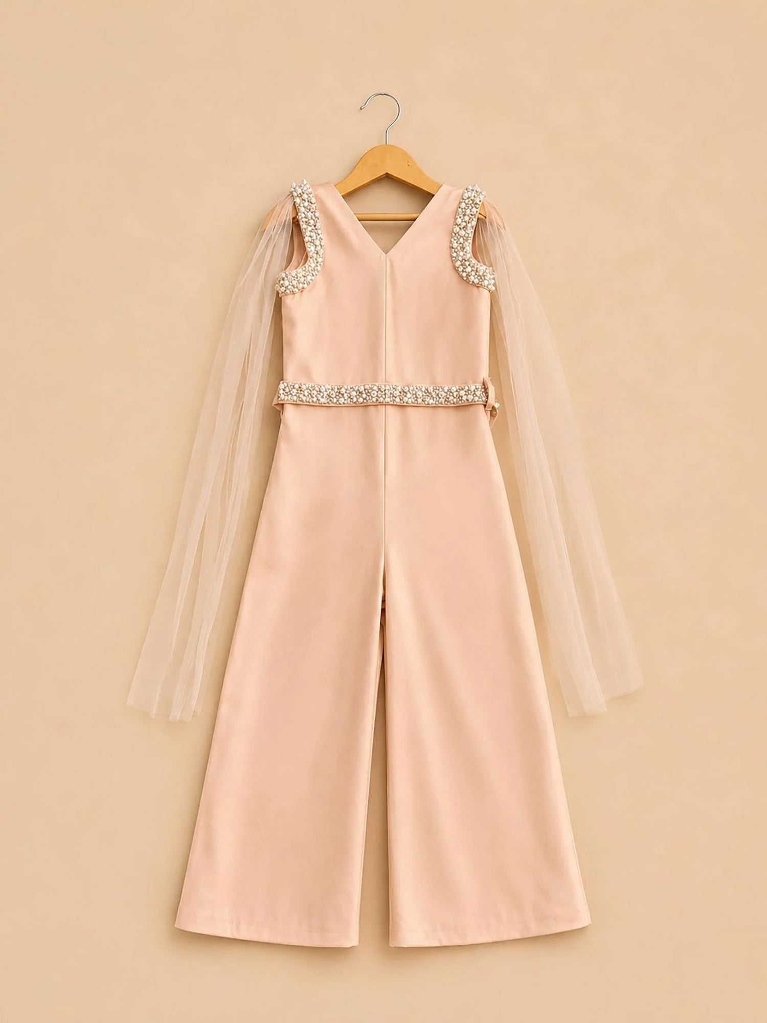 Girl wearing Storytellers Junior Elara Peach Pearl Jumpsuit with tulle sleeves and pearl embellishments