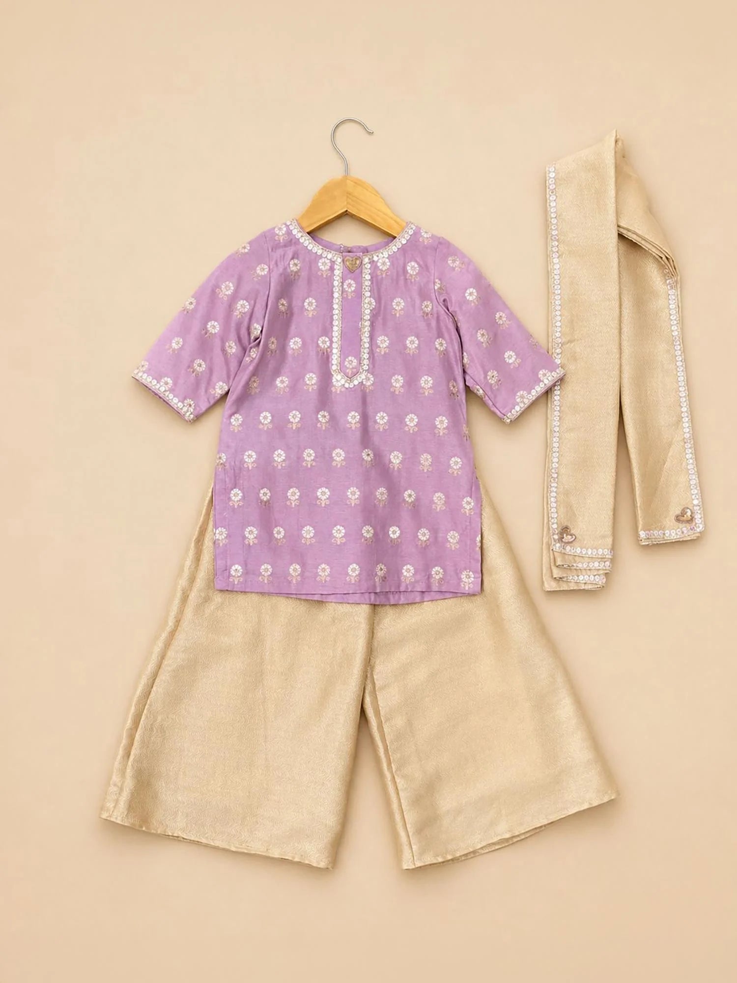 Girl wearing Storytellers Junior Noor Lavender Sharara Set with gold sharara and dupatta