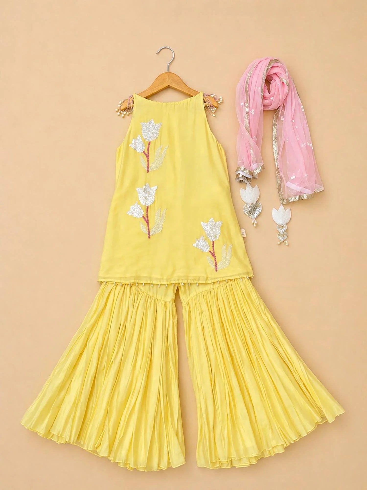 Girl wearing Storytellers Junior Zara Yellow Sharara Set with pink dupatta and floral embroidery